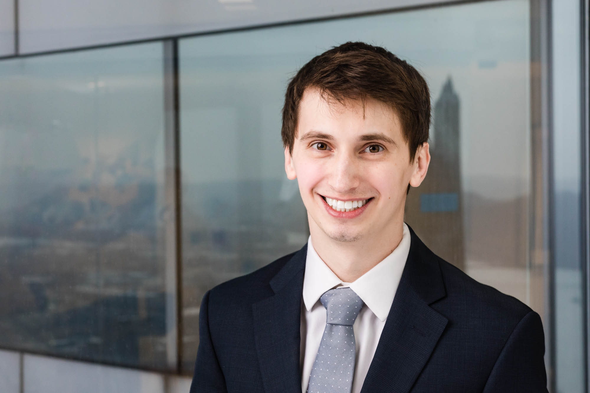 environmental portrait of young male professional with Pittsburgh city in background